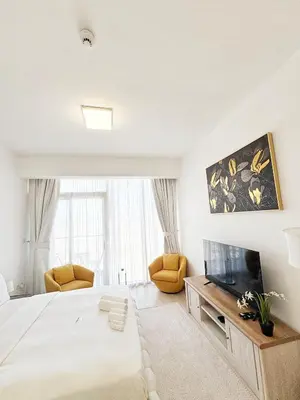 a bedroom with a large bed and a tv at Modern Fully Furnished Apartment in Bloom Tower B JVC - Easy Access to JBR, Circle Mall & Dubai Hills Mall in Dubai