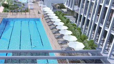 an overhead view of a swimming pool with chairs and umbrellas at Modern Fully Furnished Apartment in Bloom Tower B JVC - Easy Access to JBR, Circle Mall & Dubai Hills Mall in Dubai