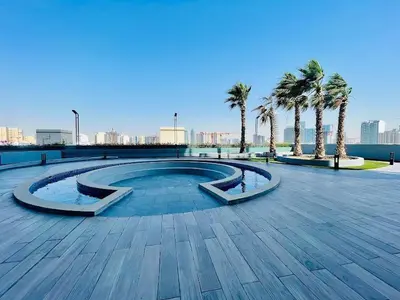 a swimming pool with palm trees in a park at Modern Fully Furnished Apartment in Bloom Tower B JVC - Easy Access to JBR, Circle Mall & Dubai Hills Mall in Dubai