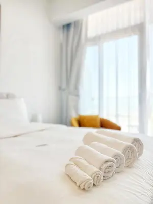a white bedroom with towels on a bed at Modern Fully Furnished Apartment in Bloom Tower B JVC - Easy Access to JBR, Circle Mall & Dubai Hills Mall in Dubai