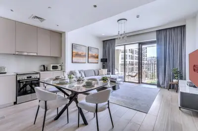 a kitchen and living room with a table and chairs at GuestReady - Modern design in Dubai Creek Harbour in Dubai