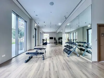 a gym with treadmills and elliptical machines at GuestReady - Modern design in Dubai Creek Harbour in Dubai