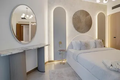 a bedroom with a white bed and a mirror at 26- Apartment in Business Bay Dubai with Balcony & Pool in Dubai