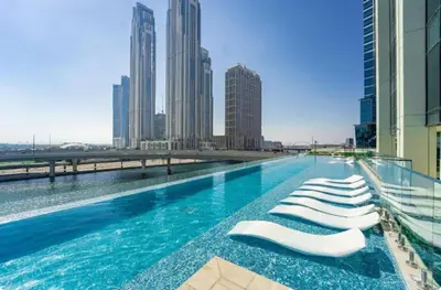 a swimming pool with chaise lounge chairs on a building at 26- Apartment in Business Bay Dubai with Balcony & Pool in Dubai