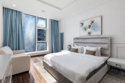 a bedroom with a large bed and a window at Modern 1BD, beautiful SeaView, Pool & Beach access in Dubai