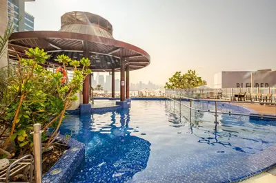 a swimming pool at a hotel with a building at Modern 1BD, beautiful SeaView, Pool & Beach access in Dubai