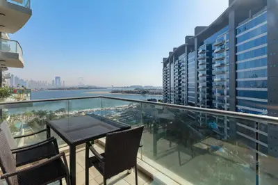 a balcony with a table and chairs on a building at Modern 1BD, beautiful SeaView, Pool & Beach access in Dubai