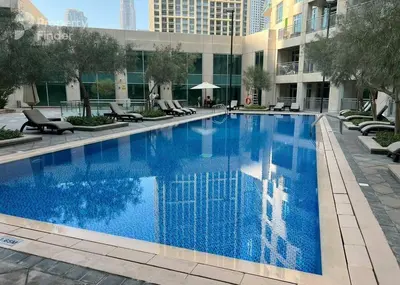 a large blue swimming pool in a building at Vibrant 2BR in Burj Views - Near Dubai Mall & Burj in Dubai