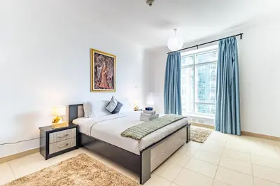 a bedroom with a bed and a large window at Vibrant 2BR in Burj Views - Near Dubai Mall & Burj in Dubai