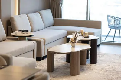 a living room with a couch and two tables at Luxury Canal Front with Burj Khalifa Skyline View in Dubai