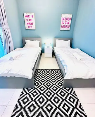 two twin beds in a room with a rug at Vibrant Marina Retreat! in Dubai