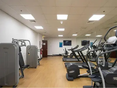 a gym with rows of treadmills and machines at Vibrant Marina Retreat! in Dubai