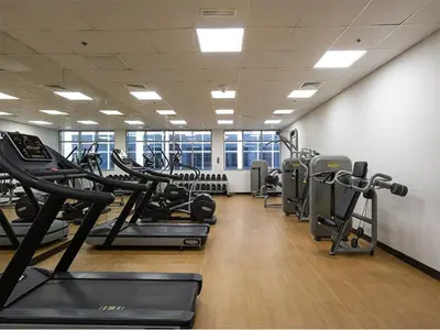 a gym with a row of treadmills and machines at Vibrant Marina Retreat! in Dubai