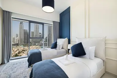 a hotel room with two beds and a large window at Lux apartment with full Burj View - 5 min walk to Dubai Mall in Dubai