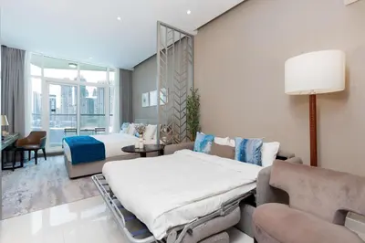 a hotel room with a bed and a couch at Luxury Canal-View Studio in Dubai