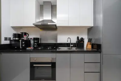 a kitchen with a sink and a stove top oven at Luxury Canal-View Studio in Dubai