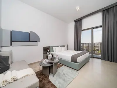 a white bedroom with a bed and a couch at Contemporary Meydan Studio Escape in Dubai