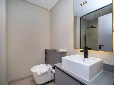 a bathroom with a sink and a toilet and a mirror at Contemporary Meydan Studio Escape in Dubai