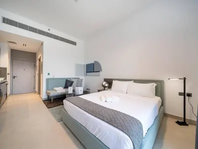 a bedroom with a large bed and a living room at Contemporary Meydan Studio Escape in Dubai