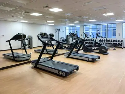 a gym with several treadmills and elliptical machines at Spacious 3 Bed Marina Haven with Waterfront Views in Dubai