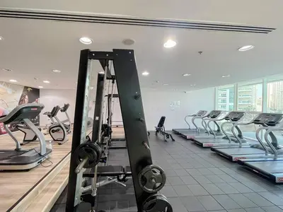 a gym with rows of exercise bikes and treadmills at Elegant 1-Bedroom Retreat with Marina Views in Dubai