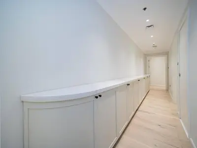 a hallway with white cabinets and a white counter in a room at Luxurious 2 Bed Waterfront Living at Marina Quays in Dubai
