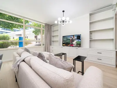 a living room with a white couch and a tv at Luxurious 2 Bed Waterfront Living at Marina Quays in Dubai