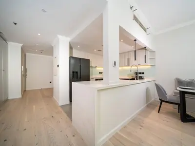 a white kitchen with a counter and a dining room at Luxurious 2 Bed Waterfront Living at Marina Quays in Dubai
