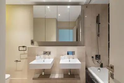 a bathroom with two sinks and a mirror at Best View Luxury 2BDR Palm Jumeirah, Beach & Pool in Dubai
