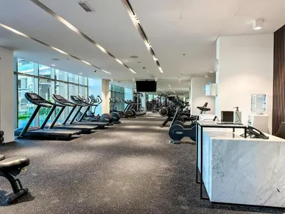 a gym with rows of treadmills and machines at Best View Luxury 2BDR Palm Jumeirah, Beach & Pool in Dubai