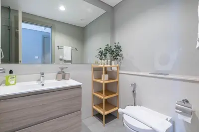 a bathroom with a sink and a toilet and a mirror at Perfect Location-For Work or Leisure in Dubai