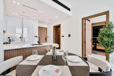 a dining room with a table and chairs and a kitchen at PVH - Elegant 1BR in Binghatti House in Dubai
