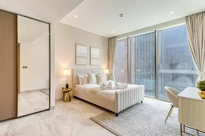 a bedroom with a bed and a large window at PVH - Lavish 1BR in Peninsula Five in Dubai
