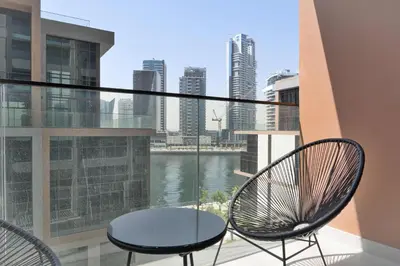 a balcony with two chairs and a view of the water at PVH - Lavish 1BR in Peninsula Five in Dubai