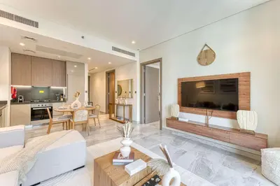a living room with a large flat screen tv at PVH - Lavish 1BR in Peninsula Five in Dubai