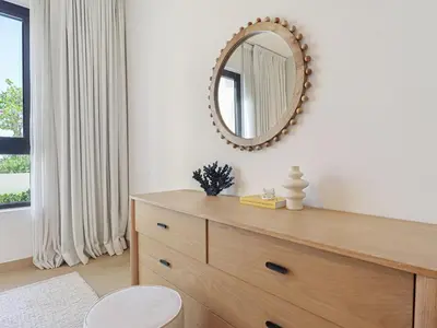 a mirror on a wall above a dresser in a room at HiGuests - Modern Escape in Jumeirah Bliss in Dubai