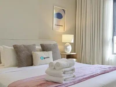 a hotel room with a bed with towels on it at HiGuests - Modern Escape in Jumeirah Bliss in Dubai