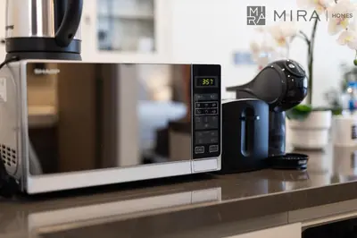 a microwave oven sitting on a kitchen counter at Stylish 1BR in Peninsula Five Views & Pool in Dubai