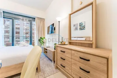 a bedroom with a large mirror and a dresser at Studio with Pool and Community View, Near Soho Garden DXB and Meydan Golf Club, Azizi Riviera 43, Al Merkadh by Deluxe Holiday Homes in Dubai