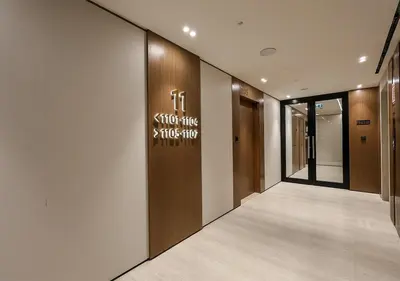 a corridor of a building with a sign on the wall at Brand New Luxurious 1 BR with Garden, Gym, Pool and Open View in Dubai