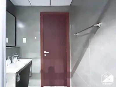 a bathroom with a dark brown door and a sink at Cozy One-Bedroom in O2 Tower, JVC in Dubai