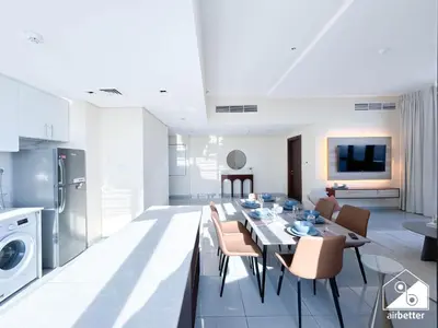a kitchen and living room with a table and chairs at Cozy One-Bedroom in O2 Tower, JVC in Dubai