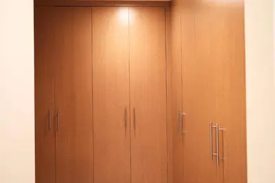 a closet with wooden cabinets in a room at Nivis find- Luxury & Spacious 1 BHK 10 mins away from Dubai mall in Dubai