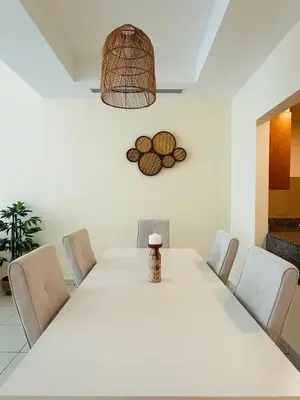 a dining room with a white table and chairs at Nivis find- Luxury & Spacious 1 BHK 10 mins away from Dubai mall in Dubai