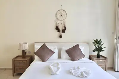 a bedroom with a white bed with a clock on the wall at Nivis find- Luxury & Spacious 1 BHK 10 mins away from Dubai mall in Dubai