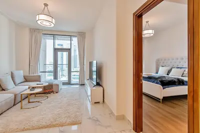 a living room with a bed and a mirror at DreamShoma-1BR Stunning Canal View in Dubai