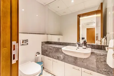 a bathroom with a sink and a toilet at DreamShoma-1BR Stunning Canal View in Dubai