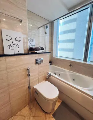 a bathroom with a toilet and a tub and a window at Dubai Marina Modern 1 Bedroom Apartment - steps to tram & Marina Walk in Dubai
