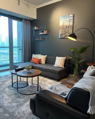 a living room with a couch and a table at Dubai Marina Modern 1 Bedroom Apartment - steps to tram & Marina Walk in Dubai