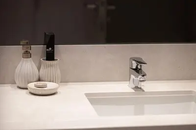 a bathroom sink with a faucet and two vases at Mahogany 9 - 2BR 10PAX - Walk to Burj & Dubai Mall in Dubai